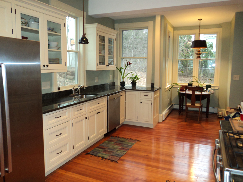 View of a kitchen in Newton. Blue walls, white cabiets and black counters